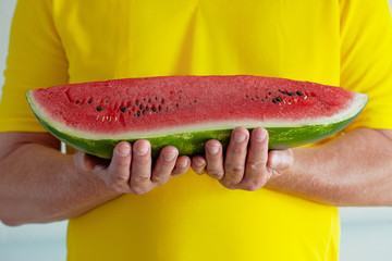 Ein Stück Reife Wassermelone in den Händen  eines Mannes