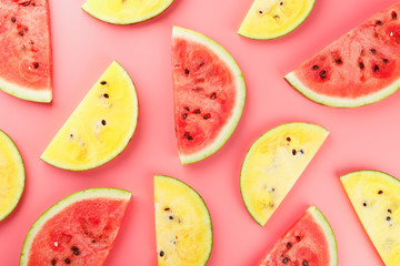 Juicy slices of red and yellow watermelon on a bright pink background. Conceptual colors of summer. Patterns top view as a background or substrate