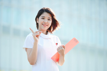 人差し指を立てる白衣の女性