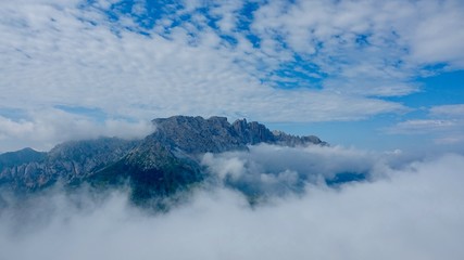 Fototapeta na wymiar Latemar Gebirgskette erwacht aus den Wolken