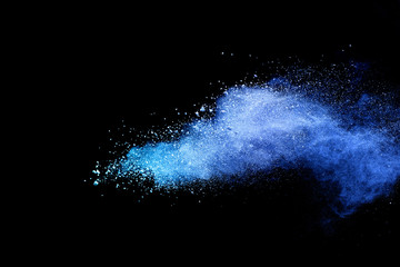 Blue powder explosion on black background. Colored cloud. Colorful dust explode. Paint Holi.