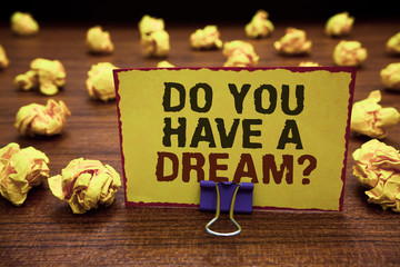 Handwriting text writing Do You Have A Dream question. Concept meaning asking someone about life goals Achievements Yellow sticky card clipped text notice crumpled paper balls wood table