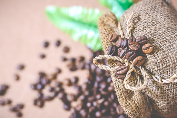 Close up coffee beans and Blur coffee beans in coffee burlap bag on old wooden background. Copy space for text.