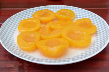 Un plato con melocotones en almíbar