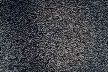 Black texture of an old gray concrete wall. Dark cement backdrop with background on the asphalt.