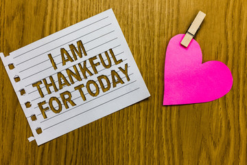 Conceptual hand writing showing I Am Thankful For Today. Business photo showcasing Grateful about living one more day Philosophy Yellow woody deck word with white page paper clip grip heart