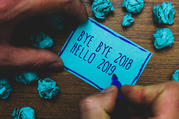 Writing note showing Bye Bye 2018 Hello 2019. Business photo showcasing Starting new year Motivational message 2018 is over Foggy hand hold marker drawn blue notepad paper lump on wooden floor © A