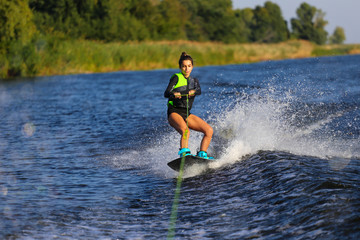 Young Sexy girl Catch waves on wakeboard when boat pulls a wakeboard 