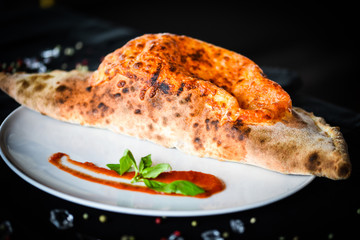 tasty italian calzone pizza with fresh ingredients and vegetables