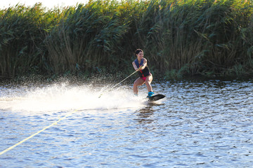 Happy girl riding on wakeboard at sunny day , smiling and happy 