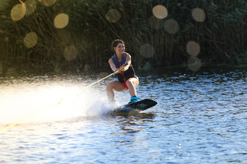 Happy girl riding on wakeboard at sunny day , smiling and happy 