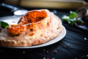 tasty italian calzone pizza with fresh ingredients and vegetables