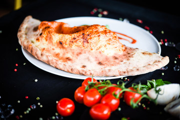 tasty italian calzone pizza with fresh ingredients and vegetables
