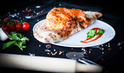 tasty italian calzone pizza with fresh ingredients and vegetables