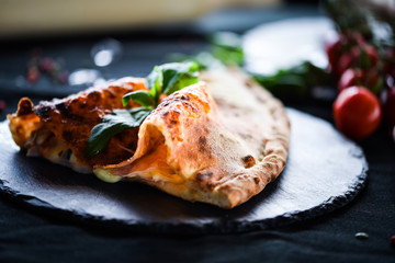 tasty italian calzone pizza with fresh ingredients and vegetables