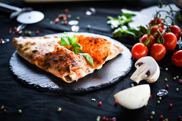 tasty italian calzone pizza with fresh ingredients and vegetables