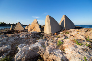 Fototapeta na wymiar Seascape. Composition of rocks and concrete pyramids. Shabla, Northern Black Sea Coast, Bulgaria.