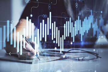 Multi exposure of woman's hands making notes with forex graph hologram. Concept of technical analysis.