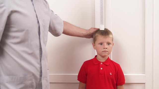 Physical therapist measuring height of a boy. Pediatric concept. Medical check-up