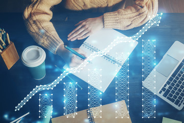 Forex graph on hand taking notes background. Concept of research. Double exposure