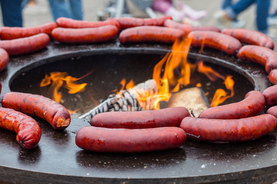 street food: grilled spicy sausages; flame of fire; firepan;