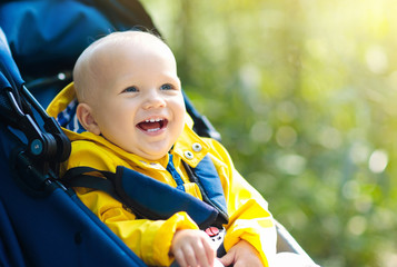 Baby boy in stroller in autumn park