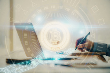 Blockchain theme hologram with man working on computer on background. Concept of crypto chain....