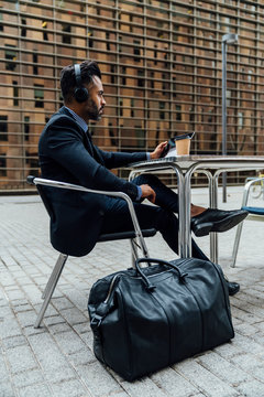 Indian Businessman Listening an Audiobook with the Headphones Ou