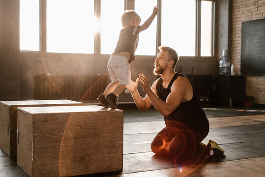 Man catching little boy?while jumping in gym