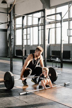 Adult man and little boy doing deadlift