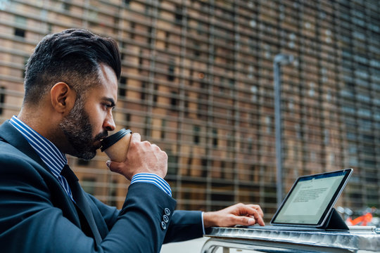 Elegant Adult Businessman Drinking a Coffee and working on His L