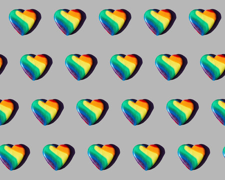 Rainbow-colored candy hearts patterned on grey