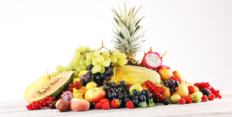 Tropical fruits background, many colorful ripe fruits with strawberries, grapes and cherries on...