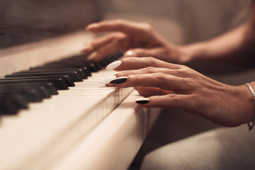 caucasian female playing on a piano close up on hands