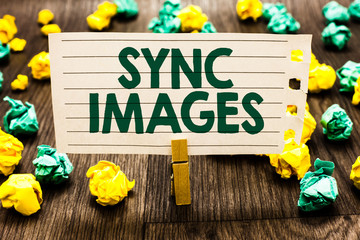 Fototapeta premium Text sign showing Sync Images. Conceptual photo Making photos identical in all devices Accessible anywhere Clothespin holding notebook paper crumpled papers several tries mistakes