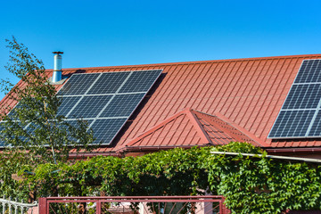 Solar panels on the roof of a country house, environmental production of solar energy in electrical.