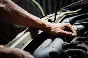 Hand of technician repair and maintenance engine of automobile in service station