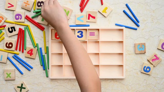 kid doing division equation using counting rods