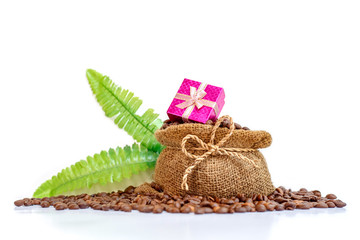 Valentine's Day concept. A pink gift box on coffee burlap bag with coffee beens isolated white background. Copy space for text.