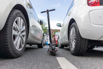 E-Scooter parked between two cars on parking place