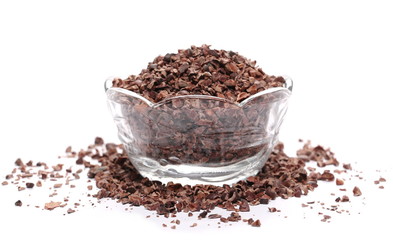 Chopped cocoa pile in glass bowl isolated on white background