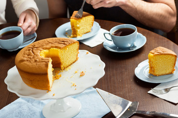 People Eating Pão de Ló, Portuguese Sponge Cake, with Hot Tea or Coffee at Table