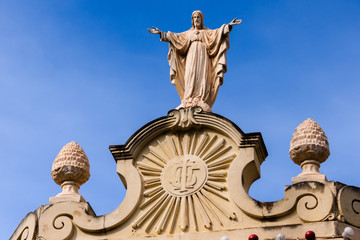 Fototapeta na wymiar Statue of Jesus at the top of the church in Nadur, Gozo, Malta.