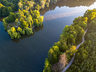 aerial veiw of empty road in green forest with the blue lake. drone shot