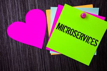 Conceptual hand writing showing Microservices. Business photo text Software development technique Decomposing an application Pinned multi colour cards heart polish dark lining background