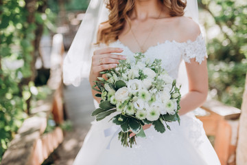 bride in white dress with a bouquet of flowers