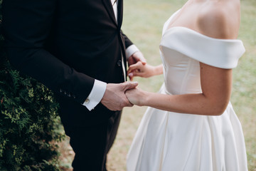bride and groom holding hands close-up