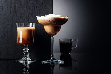 Coffee cocktails and espresso on black reflective background.