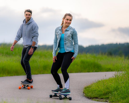 Young women and young men riding longboard