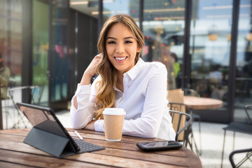 Portrait of a beautiful mixed ethnicity latin female student entrepreneur, working from laptop at...